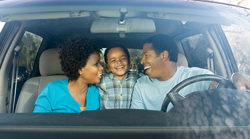 smiling african american family inside the car